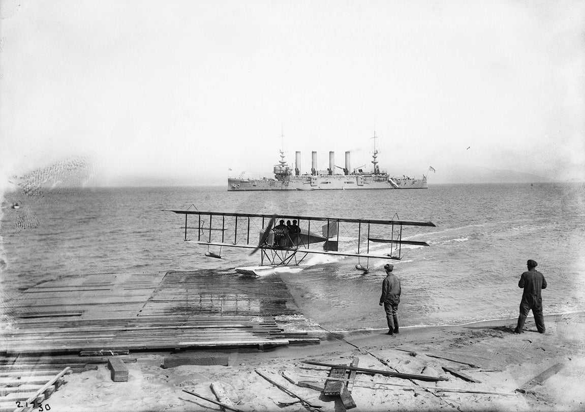 Loughead Brothers’ Alco Hydro-Aeroplane Model G beaching with the cruiser USS Milwaukee offshore, San Francisco Bay  1915