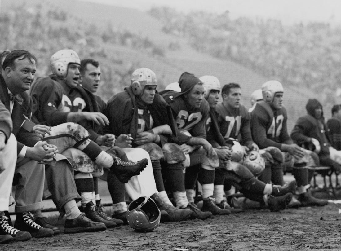 49ers bench during a game at Kezar Stadium; team physician, Frankie Albert (63), Gordy Soltau (51), Jim Powers (62), Alyn Beals (53), Verl Lillywhite (71), and Leo Nomellini (42)