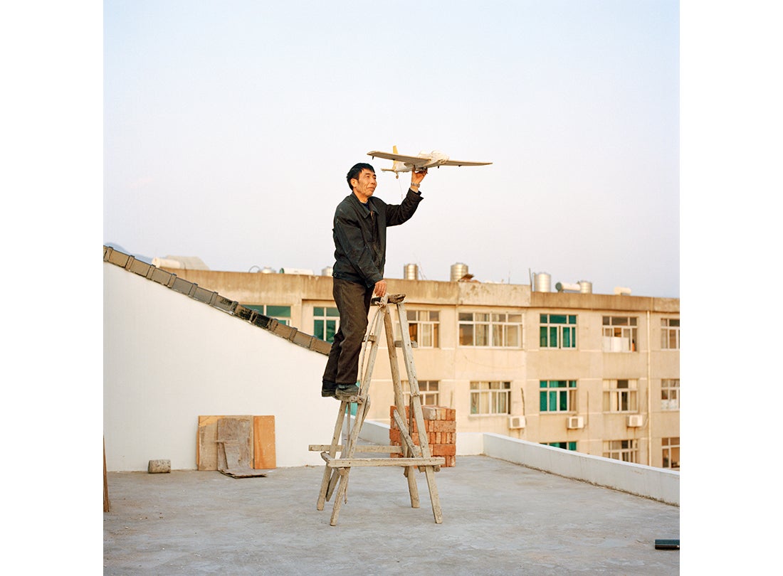 Yuan Xiangqiu holds a model airplane his son made in Tiantai, Zhejiang Province  2015
