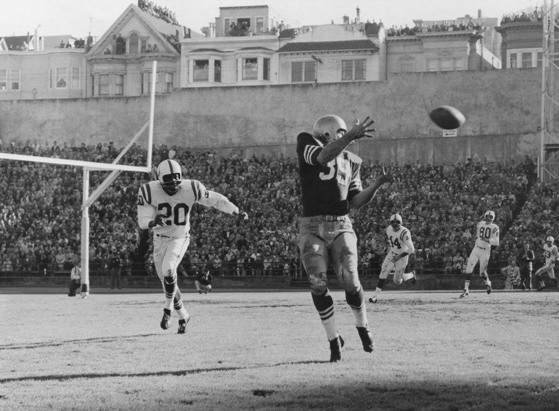 Halfback Hugh McElhenny receives a pass during a 17-13 victory over the Baltimore Colts before a crowd of 59,950 at Kezar Stadium and hundreds more crowding nearby rooftops  December 8, 1957