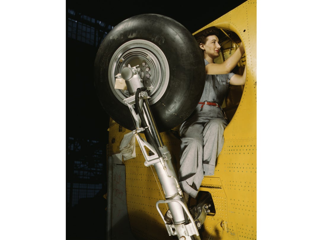 A worker makes final adjustments within the inner-wing wheel well of an Vultee A-31 Vengeance dive bomber before the installation of landing gear at the Vultee Aircraft plant
