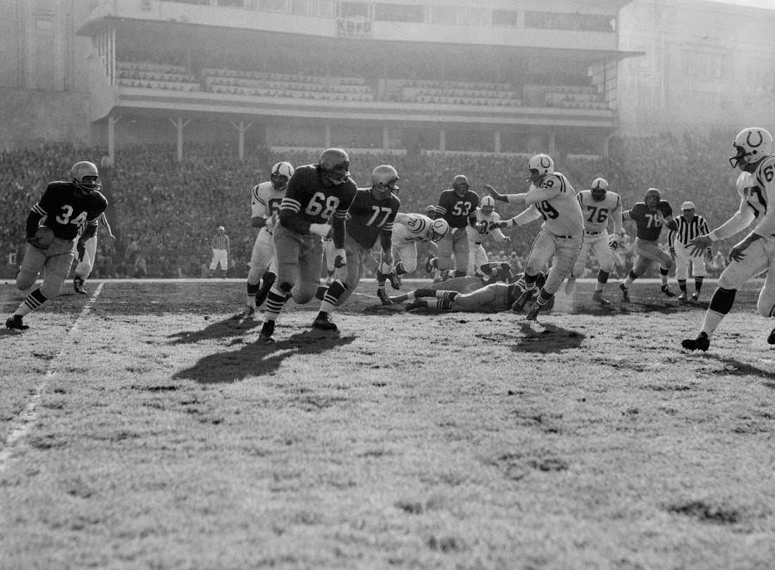 Running back Joe Perry rushes behind guards Lou Palatella (68) and Bruce Bosley (77) during a 17-13 victory over the Baltimore Colts at Kezar Stadium