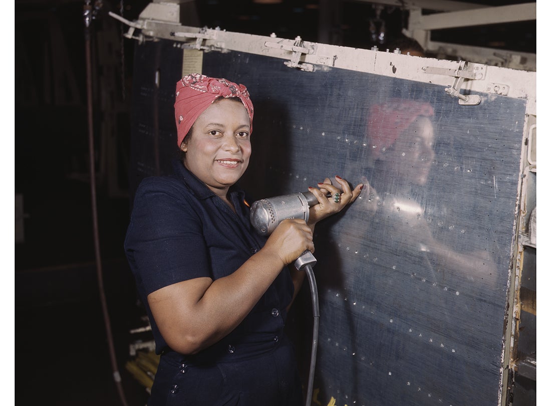 A worker operates a hand drill while working on the horizontal stabilizer of a Vultee A-31 Vengeance dive bomber at the Vultee Aircraft plant