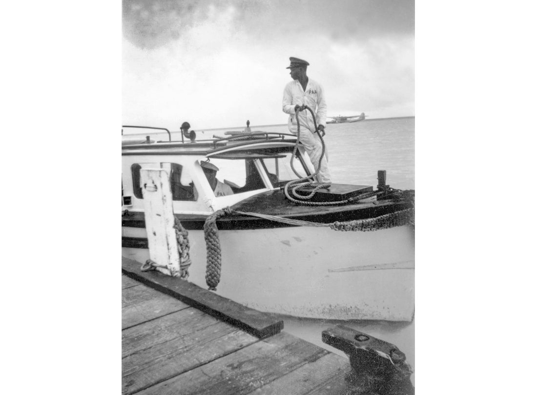 Launch and crew dockside with a Pan American Airways Martin M-130 in the lagoon, Midway Island 1938 
