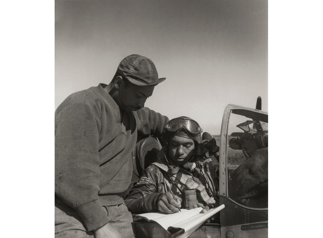 Crew chief Marcellus G. Smith with pilot Woodrow W. Crockett of the 332nd Fighter Group signing the Form One Book, indicating any discrepancies of aircraft prior to takeoff  March 1945