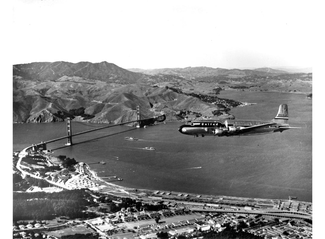 United Air Lines DC-4 flying over the Presidio, San Francisco, California c.1955