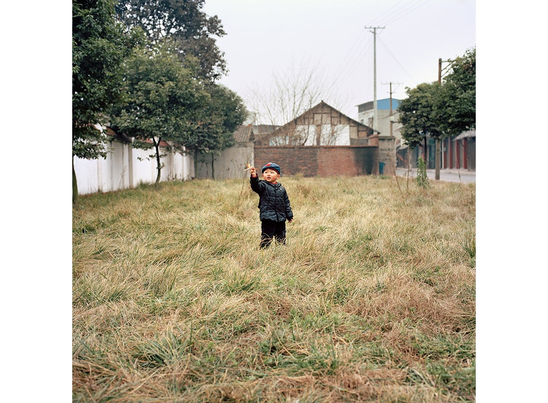 Wang Qiang’s son plays with a toy airplane  2015