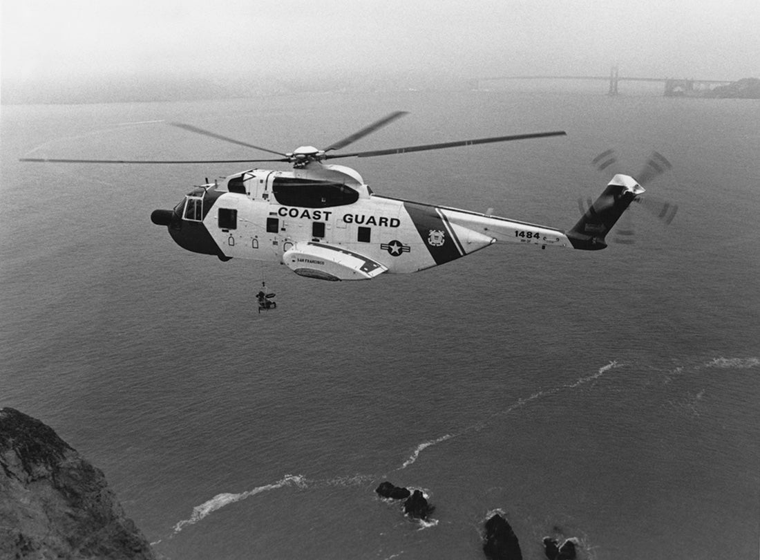 Sikorsky HH-3F Pelican helicopter hovers over Lands End with Golden Gate Bridge in background  1989