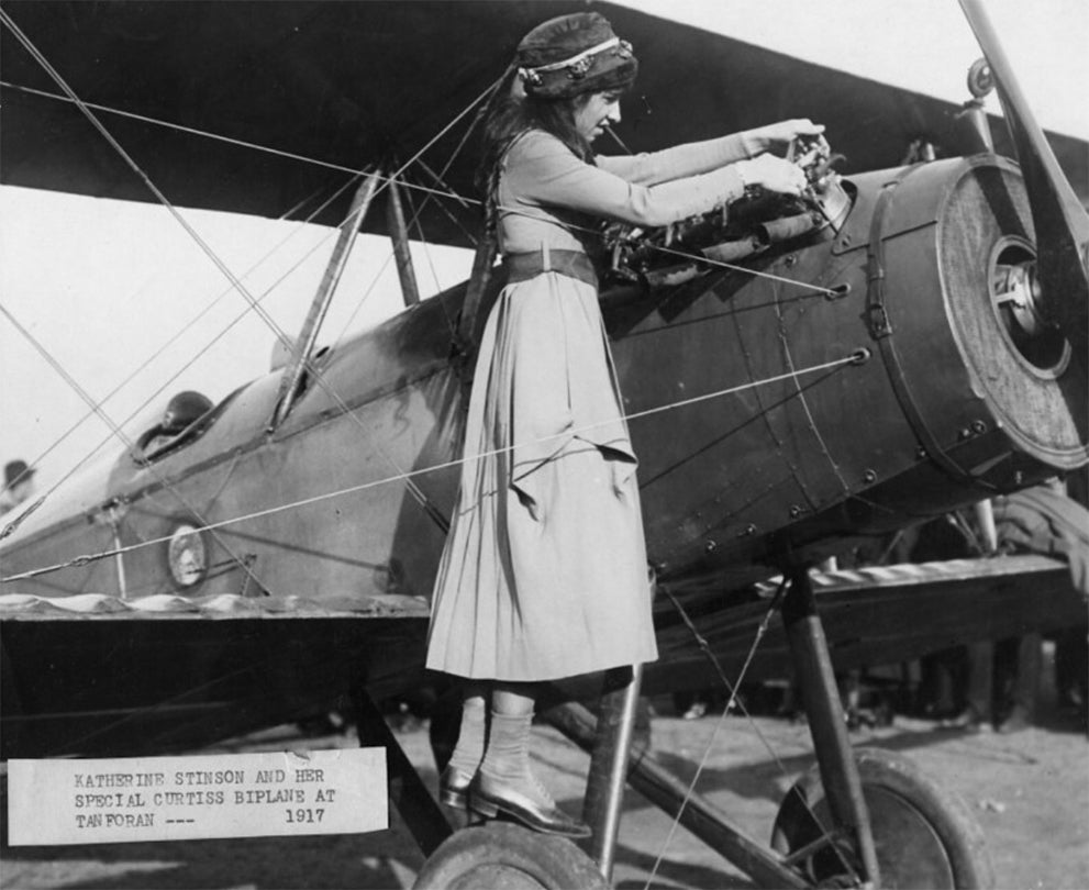 Katherine Stinson inspects the OXX-6 V-8 engine of her Curtiss-Stinson JN-4/S-3 Special biplane at Tanforan Race Track, San Bruno, California  December 30, 1917   photograph Courtesy of San Diego Air & Space Museum
