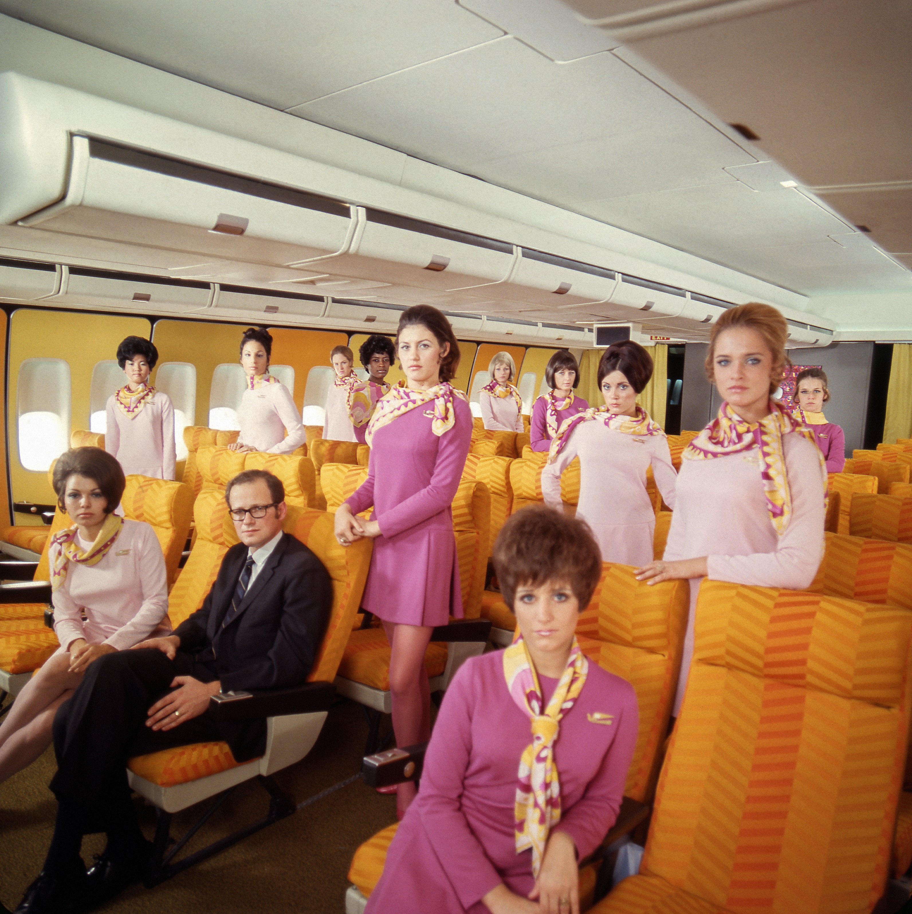 Braniff International Airways’ Chief Purser with hostesses in the first class section of the “747 Braniff Place” Boeing 747 widebody airliner  c. 1970