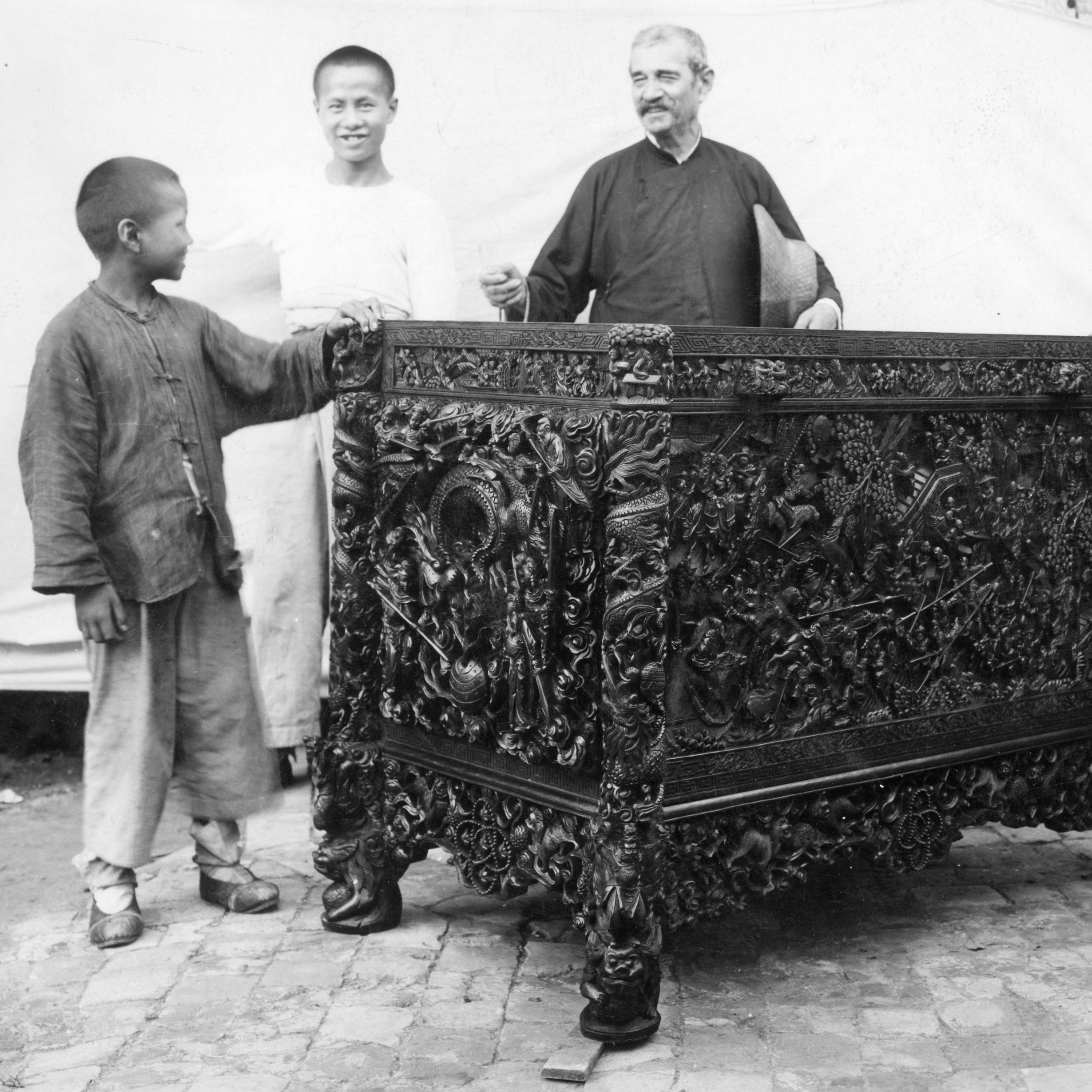 Brother Aloysius Beck and three orphans posing with their handiwork at the Tushanwan Catholic orphanage and woodshop