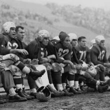 49ers bench during a game at Kezar Stadium; team physician, Frankie Albert (63), Gordy Soltau (51), Jim Powers (62), Alyn Beals (53), Verl Lillywhite (71), and Leo Nomellini (42)