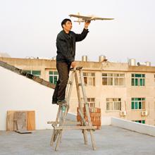Yuan Xiangqiu holds a model airplane his son made in Tiantai, Zhejiang Province  2015