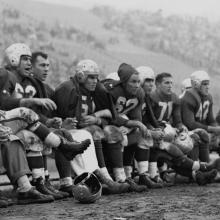 49ers bench during a game at Kezar Stadium; Frankie Albert (63), Gordy Soltau (51), Jim Powers (62), Alyn Beals (53), Verl Lillywhite (71), and Leo Nomellini (42)  1950