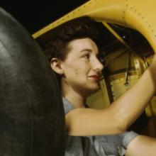 A worker makes final adjustments within the inner-wing wheel well of an Vultee A-31 Vengeance dive bomber before the installation of landing gear at the Vultee Aircraft plant