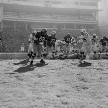 Running back Joe Perry rushes behind guards Lou Palatella (68) and Bruce Bosley (77) during a 17-13 victory over the Baltimore Colts at Kezar Stadium