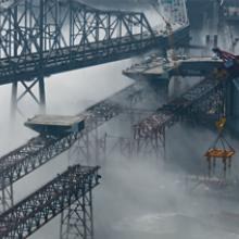 Steel-deck sections glide across falsework