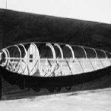 Workers holding a half-skinned fuselage frame for a Loughead Model S-1, with “Happy” Hopkins at the tail, Santa Barbara, California  1919
