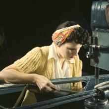 An operator of a riveting machine joins sections of wing ribs to reinforce the inner wing assemblies of Douglas-built Boeing B-17F