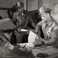 332nd Fighter Group pilot Woodrow W. Crockett and unidentified pilot in the briefing room with Group Operations Officer Edward C. Gleed  March 1945