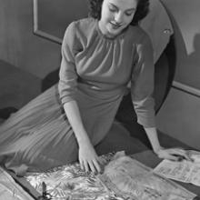 A woman demonstrates the steps in assembling a pattern and fabricating a garment at home for the Office of War Information  1943