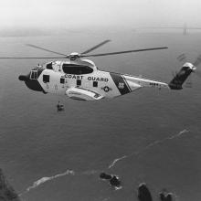 Sikorsky HH-3F Pelican helicopter hovers over Lands End with Golden Gate Bridge in background  1989