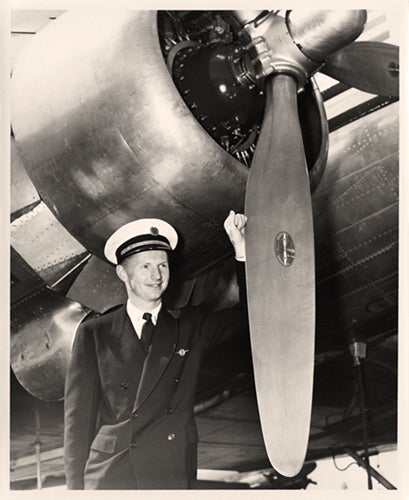 Pan American Airways Captain Roger J. Sherron, Jr. poses next to a Douglas DC-3 engine  1943